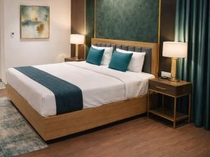a bedroom with a large bed with blue pillows at Kriya Grandeur Hotel in Secunderabad