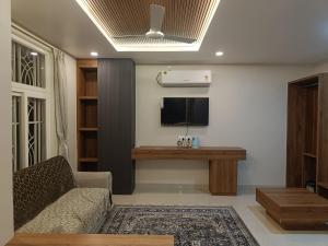 a living room with a couch and a flat screen tv at RadhaKrishna Executive in Tuljapur