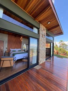 a deck with a bedroom and a bed on it at Chalé Manacá in Sapucaí-Mirim