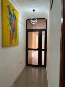 a hallway with a door and a painting on the wall at Adelpha 101 in Accra
