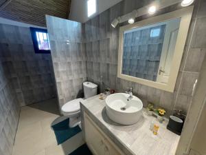 un bagno con lavandino, WC e specchio di Casa Del Mar a M'bour Altre 14 foto