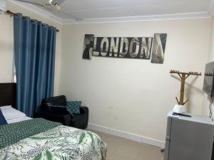 a bedroom with a bed and a cross on the wall at Adelpha 101 in Accra +1 photo