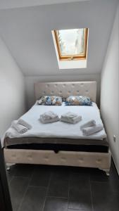 een slaapkamer met een bed met twee handdoeken erop bij Crassula Lux in Surčin