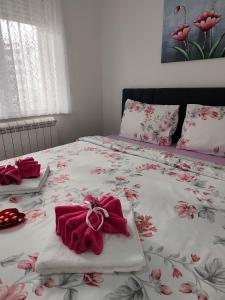 - un lit avec des couvertures rouges et des oreillers dans l'établissement Apartman LARA, à Pirot