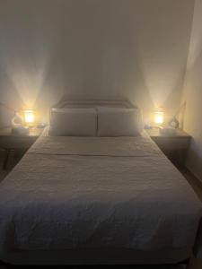 a bedroom with a bed with two lights on two tables at comfort private master room in Sharjah