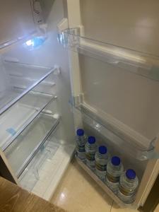 an open refrigerator with bottles of water in it at comfort private master room in Sharjah