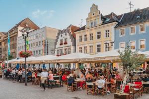 een groep mensen die aan tafels in een straat zitten bij Exklusives Studio - Zentral Innenstadtlage - Kostenloser Parkplatz - Aufzug - Modern für bis zu 4 Personen - Smart Home in Recklinghausen