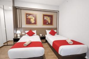 two beds with red and white pillows in a room at Panoramic Sea view 2BR Duplex High Floor George Town 203A Maritime Suite in George Town +16 photos