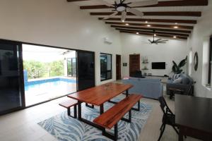 un salon avec une table et une piscine dans l'établissement Sunset Oasis Waterfront, à Maya Beach