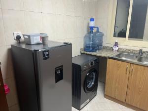 a kitchen with a washing machine and a sink at comfort private master room in Sharjah