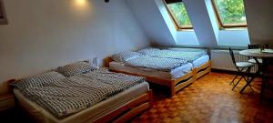 twee bedden in een kamer met een tafel en twee ramen bij Ubytování na Křížovce in Chlum u Třeboně