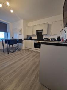 una grande cucina con mobili bianchi e un tavolo di Rook View, Modern Coastal Retreat with Free Parking a Buckie Altre 9 foto