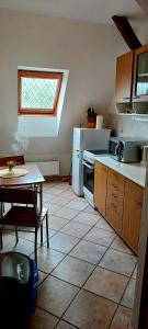 een keuken met een tafel, een fornuis en een raam bij Ubytování na Křížovce in Chlum u Třeboně