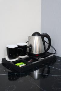 a tea kettle and two cups on a tray at AURA camping in Zhezdi