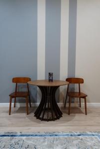 a table and two chairs in a room at AURA camping in Zhezdi