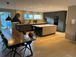 a kitchen with a wooden table and a kitchen with a counter at Skovbrynets guesthouse in Herning