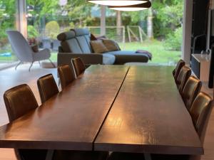 a wooden table and chairs in a living room at Skovbrynets guesthouse in Herning +10 photos