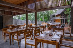 a dining room with wooden tables and chairs at VeeRaa Retreat in Habarana