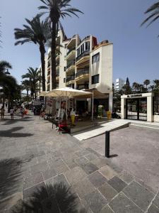 a building with palm trees in front of it at Joy and Friends 2 El Carmen in Los Cristianos