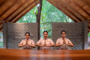 a group of three men standing in front of a table with theirselvesselvesselves at VeeRaa Retreat in Habarana