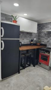 een keuken met een zwarte koelkast en een houten tafel bij Depto Roko in Villa Gesell +1 foto