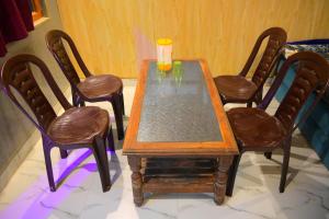 a wooden table with four chairs and a cup on it at Mahakal homestay in Ayodhya