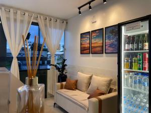 a living room with a couch and a drink refrigerator at Pousada Mar de Luna in Penha