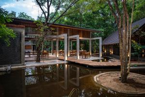 a house with a wooden deck in the water at VeeRaa Retreat in Habarana
