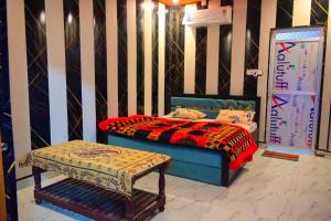 a bedroom with a bed and a bench in it at Mahakal homestay in Ayodhya