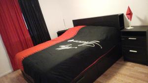 a bedroom with a bed with a black and orange bedspread at Fritidslägenhet Hyltebruk in Hyltebruk