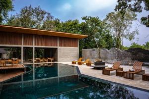 a swimming pool in front of a house at VeeRaa Retreat in Habarana