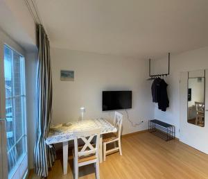 a dining room with a table and a television in a room at Inselpause in Wittdün