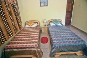 two beds sitting next to each other in a bedroom at Sheetal Homestay in Varanasi