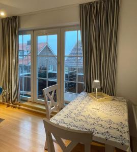 a dining room with a table and a large window at Inselpause in Wittdün