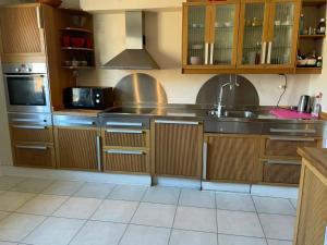 a kitchen with wooden cabinets and stainless steel appliances at Fritidslägenhet Hyltebruk in Hyltebruk