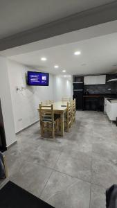 een eetkamer met een tafel en een tv aan de muur bij Depto Roko in Villa Gesell