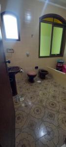 a bathroom with two toilets and a sink and a window at Suíte da Virada in Guarujá