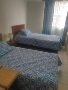 a bedroom with two beds and a table at Depto Condominio La Casona in El Quisco