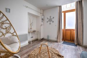 a living room with a chair and a window at les doux secrets de Bergère in Périgueux