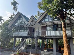 une maison avec 2 balcons et un arbre dans l'établissement Nefs Dreams Villa, à Vaduvanchal
