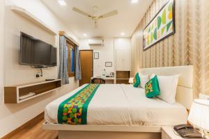 a bedroom with a large bed and a tv at Treebo Advantage Inn in Allahābād