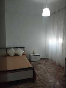 ein Schlafzimmer mit einem Bett und einem Tisch und einer Lampe in der Unterkunft El Lucentino in Lucena