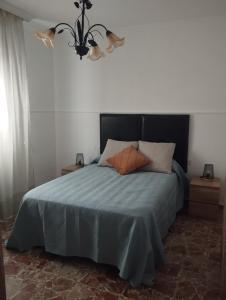 ein Schlafzimmer mit einem Bett mit einer blauen Bettdecke in der Unterkunft El Lucentino in Lucena