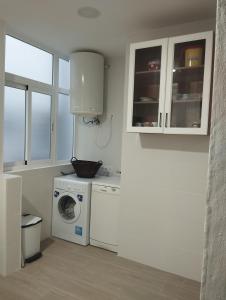 eine Küche mit Waschmaschine und Mikrowelle in der Unterkunft El Lucentino in Lucena