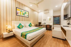 a bedroom with a large bed and a desk at Treebo Advantage Inn in Allahābād +47 photos