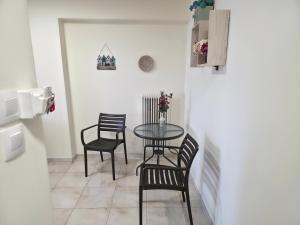 a dining room with a table and four chairs at 2Steps to the Lake in Kastoria