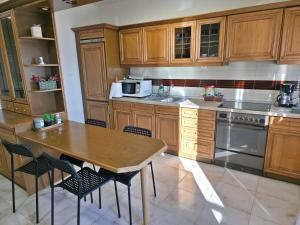 a kitchen with wooden cabinets and a wooden table with chairs at 2Steps to the Lake in Kastoria