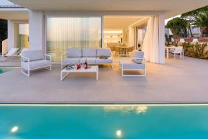 un soggiorno con divano e sedie accanto alla piscina di Bedda Matri a Noto