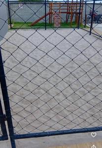 a net on a tennis court with a playground at Cantinho do Sossego in João Pessoa