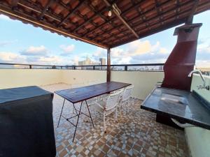 a patio with a table and a grill on a roof at Apartamento Cobertura Praia Camboinha in Cabedelo